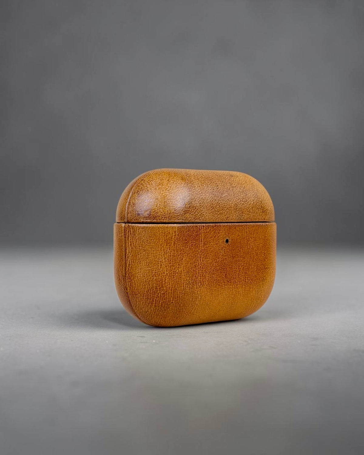 AirPods Pro 3 leather case in Siena Gold, three-quarter view #Color_Siena Gold