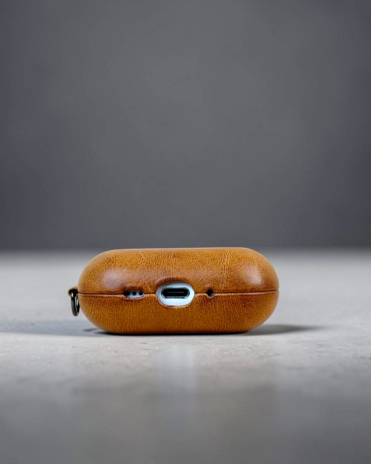 AirPods Pro 3 leather case in Siena Gold, underside with USB-C cut-out #Color_Siena Gold